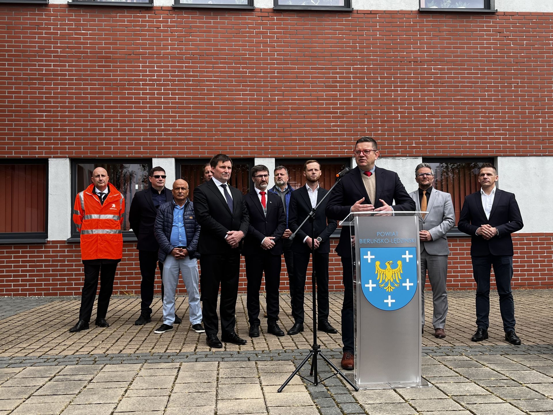 mężczyźni stojący przed budynkiem - konferencja prasowa